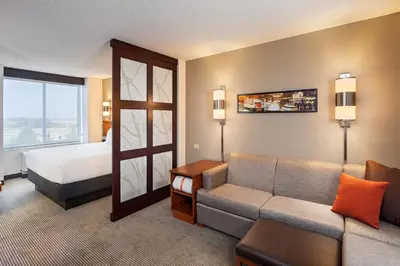 a hotel room with a couch and a bed at Hyatt Place Sacramento Roseville in Roseville