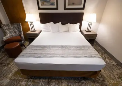 a bedroom with a bed and a chair and two lamps at Stovepipe Wells Village in Death Valley