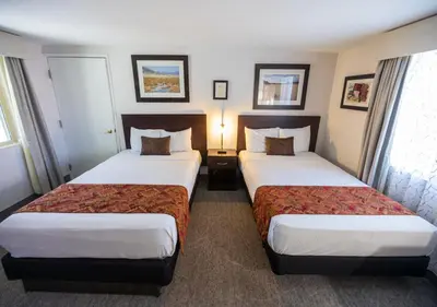 a hotel room with two beds and two windows at Stovepipe Wells Village in Death Valley