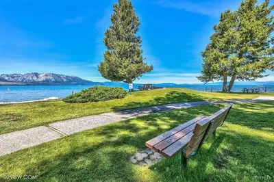 a park bench sitting on the grass near the water at 2148 Inverness Drive home in South Lake Tahoe