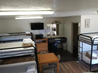a dorm room with bunk beds and a desk at Whitney Portal Hotel And Hostel in Lone Pine