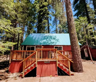 a red cabin with a green roof next to a tree at Meadow View Cabin in Wilsonia in Wilsonia