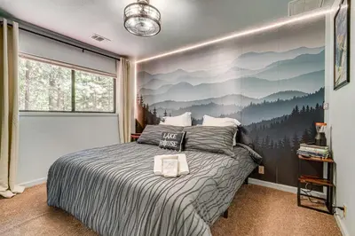 a bedroom with a bed with a mountain mural on the wall at Hike and Ski! Cabin 20 Mi to Soda Springs Mtn Resort in Emigrant Gap