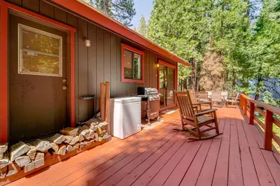 a wooden deck with a chair on a house at Hike and Ski! Cabin 20 Mi to Soda Springs Mtn Resort in Emigrant Gap