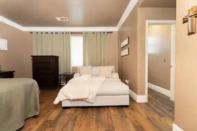 a bedroom with a white bed and a white couch at Private room--Ideal for working professionals-- in Tulare