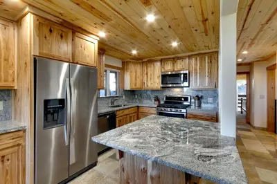a kitchen with a stainless steel refrigerator and wooden cabinets at Tall Pine Chalet home in Stateline