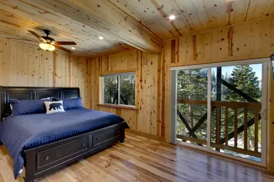 a bedroom with a bed and a ceiling fan at Tall Pine Chalet home in Stateline