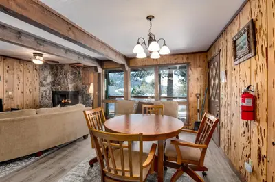 a dining room with a table and chairs and a fireplace at Snowflake Chalet condo in Stateline