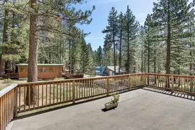 a large deck with a wooden fence and trees at Sagebrush Cottage chalet in South Lake Tahoe
