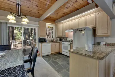 a large kitchen with white appliances and wooden cabinets at Sagebrush Cottage chalet in South Lake Tahoe