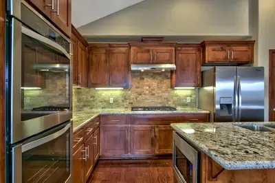 a kitchen with wooden cabinets and stainless steel appliances at Conifer Chalet condo in South Lake Tahoe