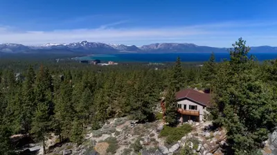 an aerial view of a house on a hill with trees at Tudor Lodge home in Stateline