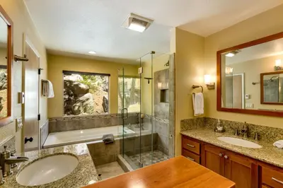 a bathroom with two sinks and a shower at Tudor Lodge home in Stateline