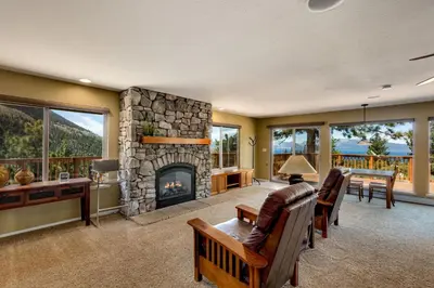 a living room with a fireplace and a table and chairs at Tudor Lodge home in Stateline