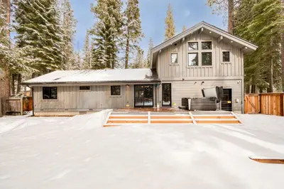 a house covered in snow in front of a house at Splendid at Chamberlands by Tahoe Getaways - Chamberlands HOA, Private Hot Tub & Walk to Lake Tahoe in Tahoma