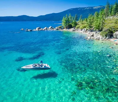 a boat in the middle of a body of water at Tahoe Townhome-Lake-Beach-Pool-Amenities in Incline Village