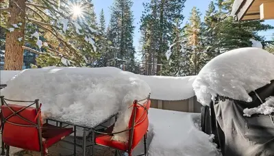 a table and two chairs covered in snow at Tahoe Townhome-Lake-Beach-Pool-Amenities in Incline Village
