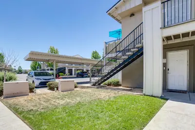 a building with a garage and a car parked in a parking lot at 3 Mi to Dtwn Gated Condo with Patio in Reno! in Reno