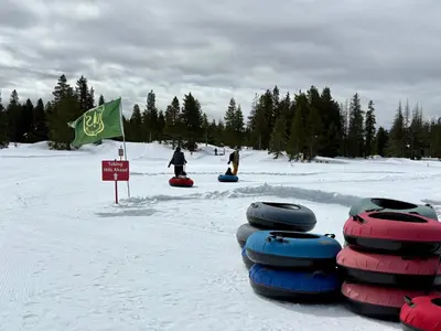 a group of tubes in the snow with a green flag at Mountain retreat w FirePit, BBQ, Karaoke, PingPong in Arnold