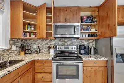 a kitchen with a stove and a microwave at Reno Retreat-Near Downtown-UNR-Family Fun in Reno