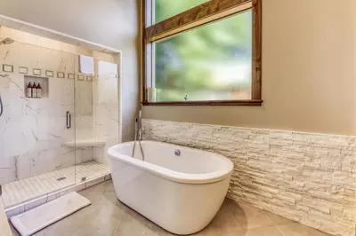 a bathroom with a tub and a shower and a window at The Lodge at Silverado in Tahoe City