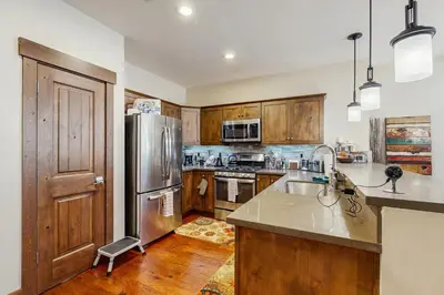 a kitchen with wooden cabinets and a stainless steel refrigerator at TruckeeTime in Truckee