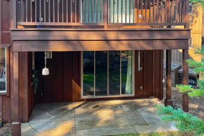 a wooden house with a large window on a patio at TruckeeTime in Truckee