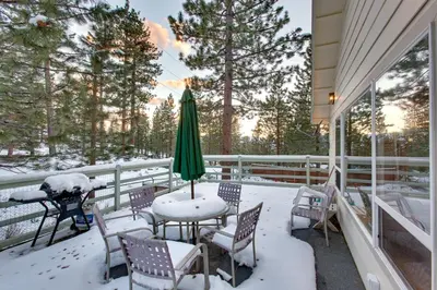 a patio with a table and chairs in the snow at Sequoia Chalet home in Stateline