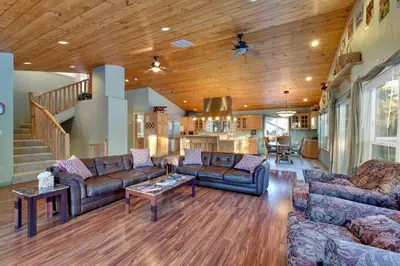 a large living room with couches and a staircase at Sequoia Chalet home in Stateline