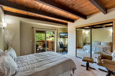 a master bedroom with a large bed and a balcony at Cold Creek Lodge home in South Lake Tahoe