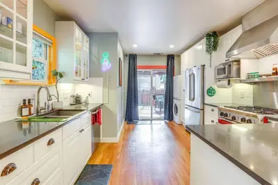 a kitchen with white cabinets and a wooden floor at Midtown Oasis w BBQ Deck Games and Artistic Vibes in Sacramento