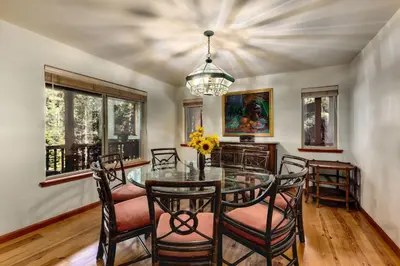 a dining room with a glass table and chairs at Silver Rock Lodge home in Zephyr Cove