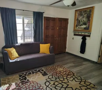 a living room with a brown couch and a rug at Dew Drop Inn Kings Canyon National Park in Miramonte