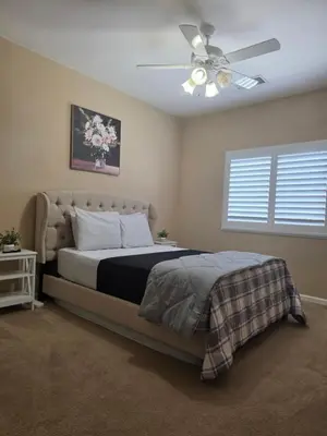 a bedroom with a bed and a ceiling fan at Tanglewood Place in Visalia
