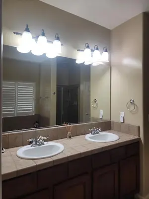a bathroom with two sinks and a large mirror at Tanglewood Place in Visalia