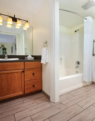 a bathroom with a large mirror and a sink and a tub at Wyndham Angels Camp 1BR Apartment with Resort Access in Angels Camp