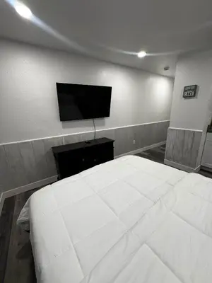 a bedroom with a large white bed and a flat screen tv at #10 Lakeside Great Location Beach Access Dogs ok in Kings Beach