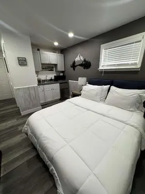 a bedroom with a large white bed and a kitchen at #10 Lakeside Great Location Beach Access Dogs ok in Kings Beach