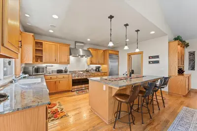 a kitchen with wooden cabinets and a large island with bar stools at Wooded Escape in Tahoe Vista Private Hot Tub in Tahoe Vista
