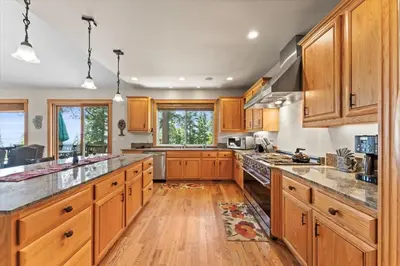 a large kitchen with wooden cabinets and wooden floors at Wooded Escape in Tahoe Vista Private Hot Tub in Tahoe Vista