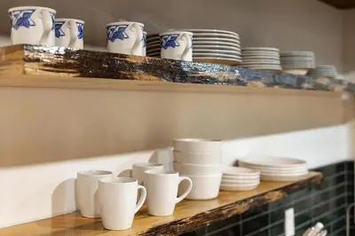 a shelf with white cups and plates on it at Stay At 4K in Arnold
