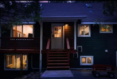a black house with a white door and stairs at Stay At 4K in Arnold
