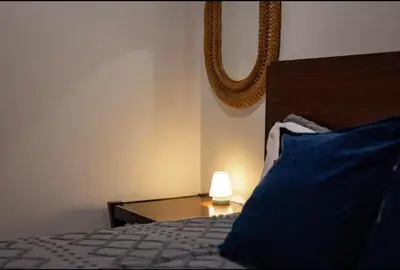 a bed with a blue pillow and a lamp on a table at Stay At 4K in Arnold