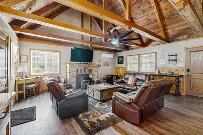 a living room with leather furniture and a fireplace at Little Cozy Cabin in Shaver Lake