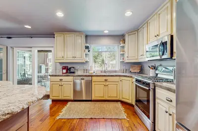 a kitchen with yellow cabinets and a wooden floor at Serenity Summit in South Lake Tahoe