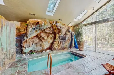 a swimming pool in a room with a rock wall at Serenity Summit in South Lake Tahoe