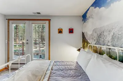 a bedroom with a mountain mural on the wall at The Rikz Cabin in South Lake Tahoe