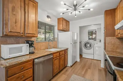 a kitchen with wooden cabinets and a washer and dryer at Tahoe Peaks & Shores Getaway in Kings Beach