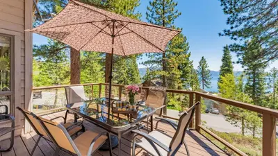 a patio with a glass table and chairs and an umbrella at Crystal View by AvantStay Al Fresco Dining w View of Lake Tahoe Crystal Bay in Incline Village