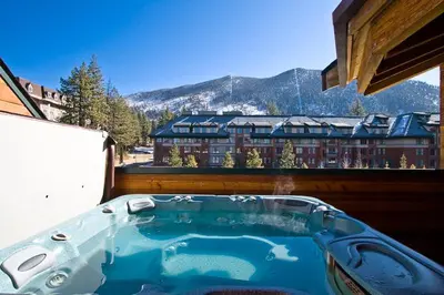 a hot tub on a balcony with a view of a building at Downtown Penthouse condo in South Lake Tahoe